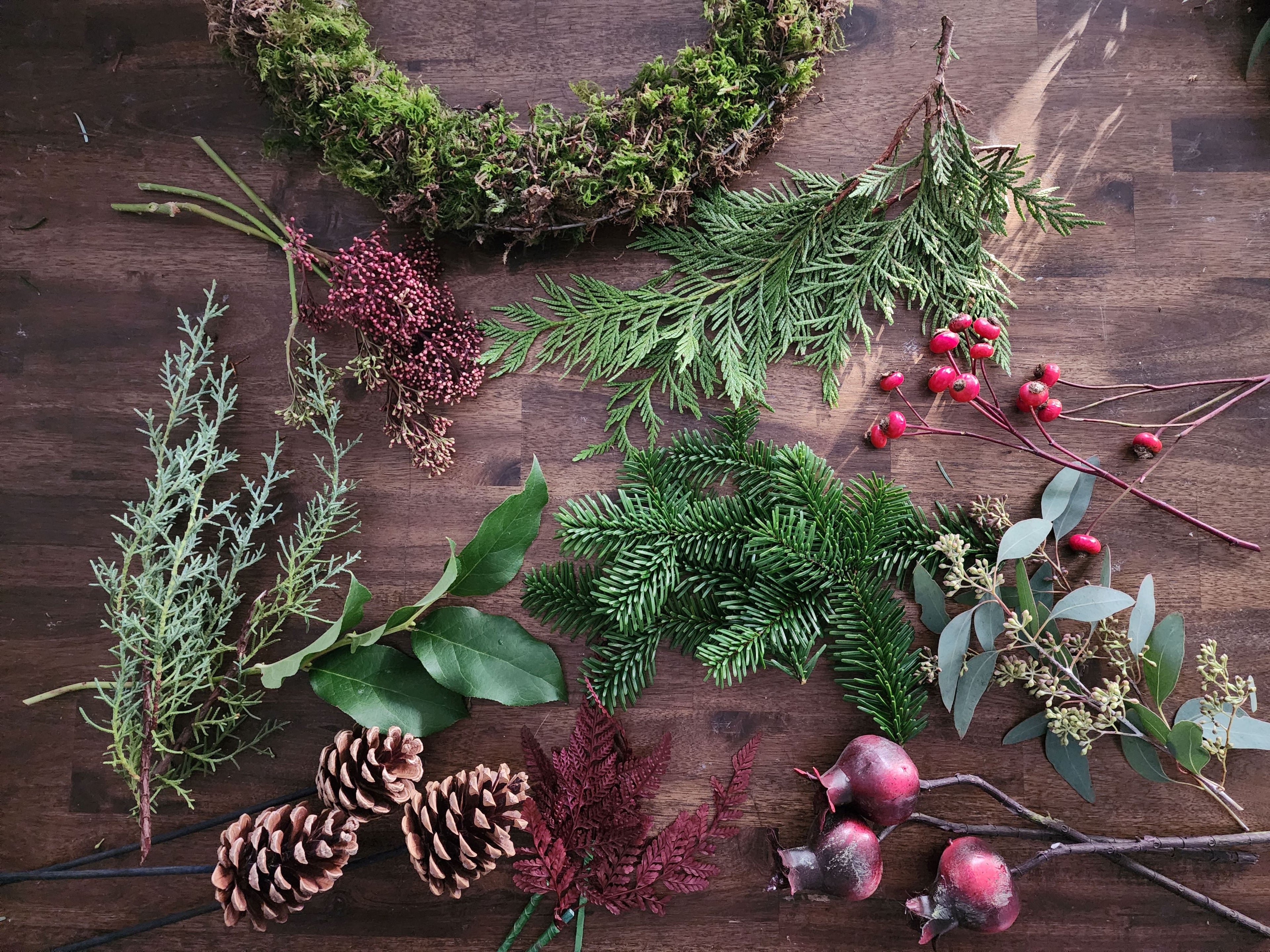 Assorted greenery and decorative elements on a wooden surface